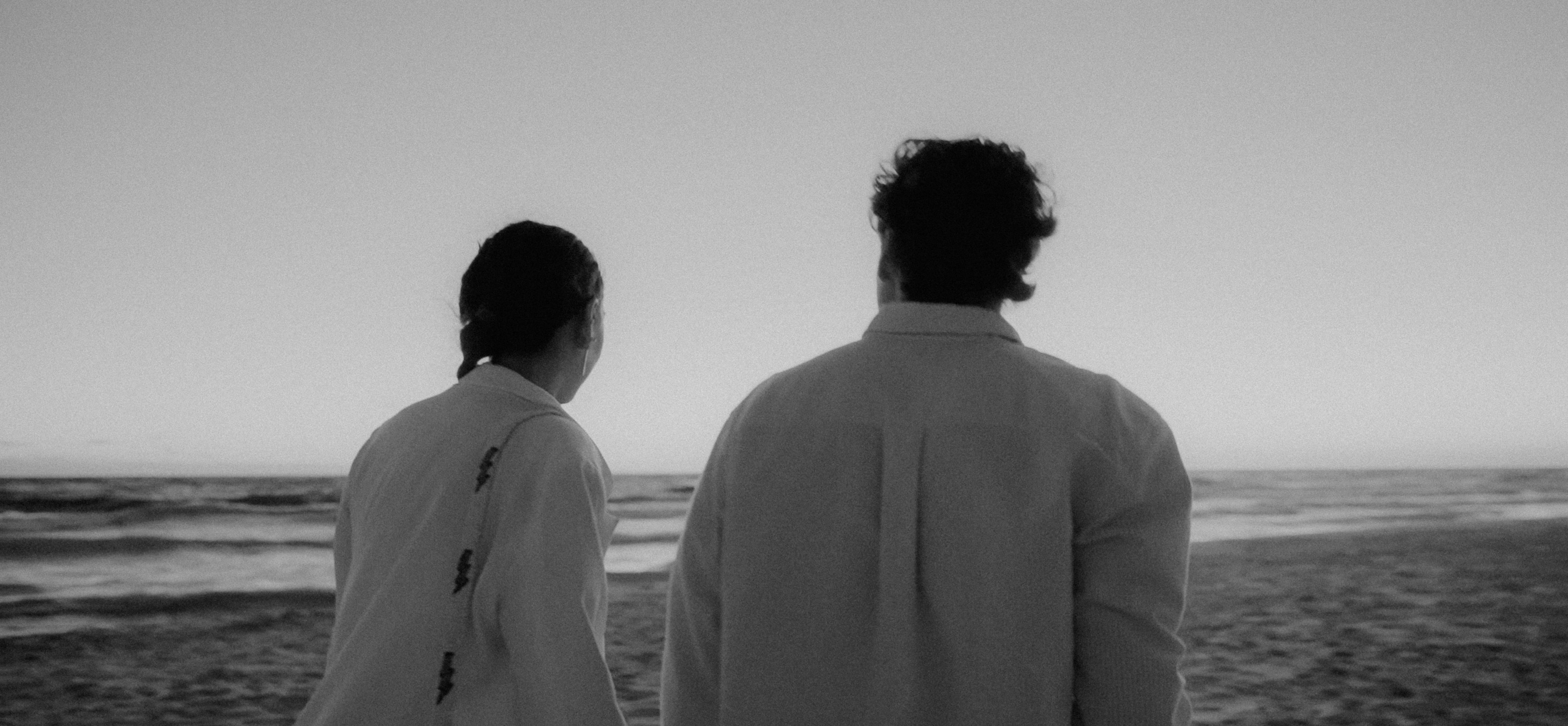 a couple of people standing on top of a beach