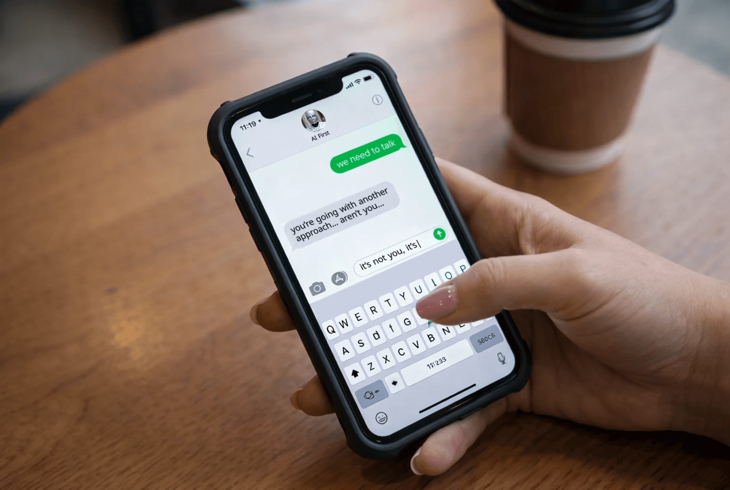 A woman's hand is holding a cellphone and sending a text that says "we need to talk" to a contact named AI First, who replies "you're going with another approach aren't you", to which the woman's hand has started to type "it's not you it's"