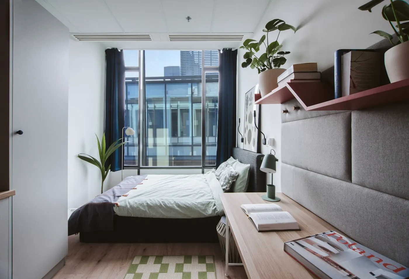 Compact student studio accommodation in Warsaw with bed, desk and kitchenette