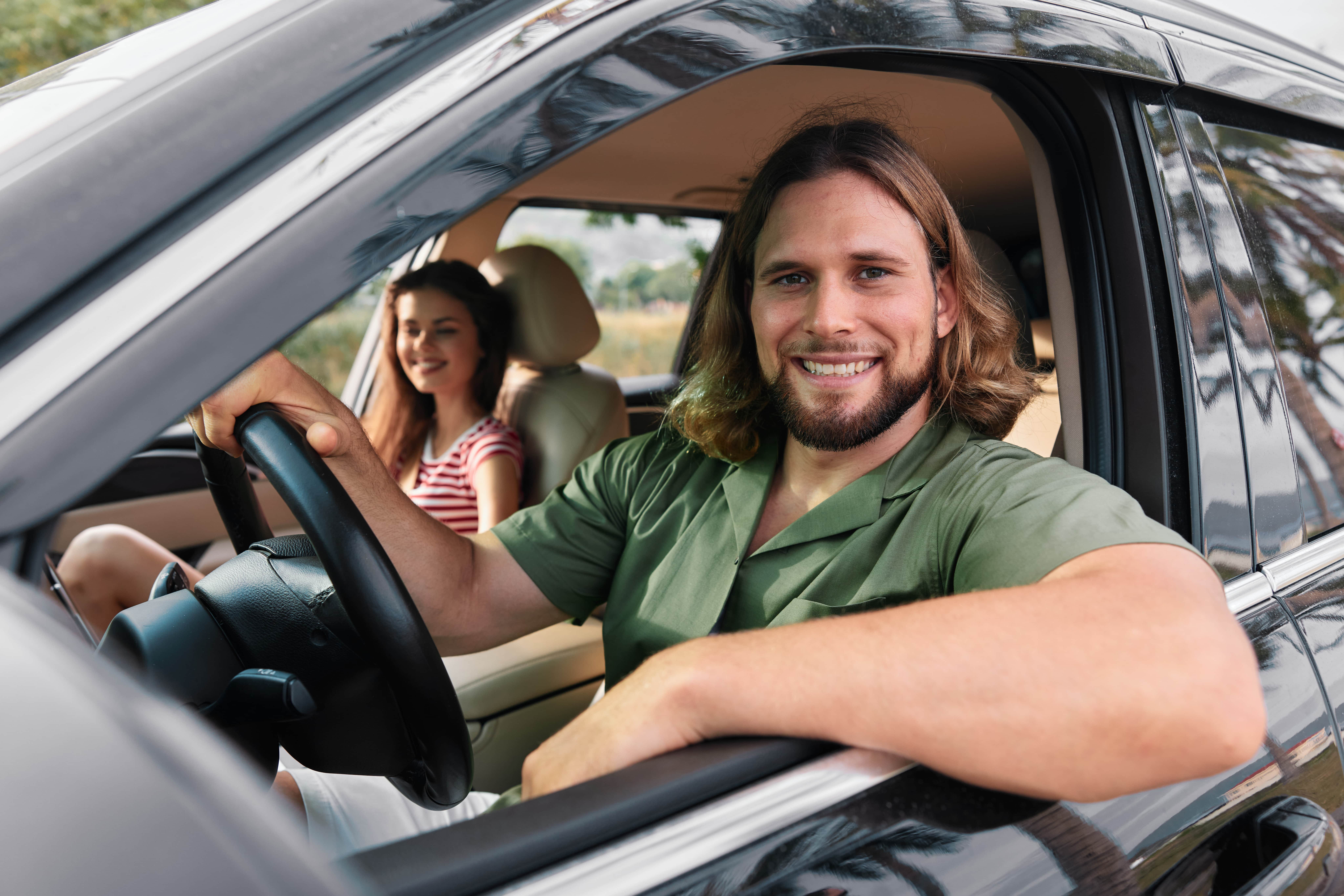 Glücklicher Mann nach bestandener MPU sitzt lächelnd am Steuer seines Autos – erfolgreiche MPU-Vorbereitung und Beratung für sicheres Fahren in Deutschland.