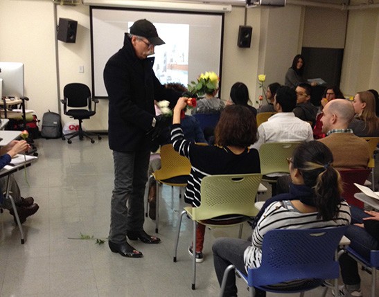 A photo of a teacher receiving flowers from the students in a classroom.
