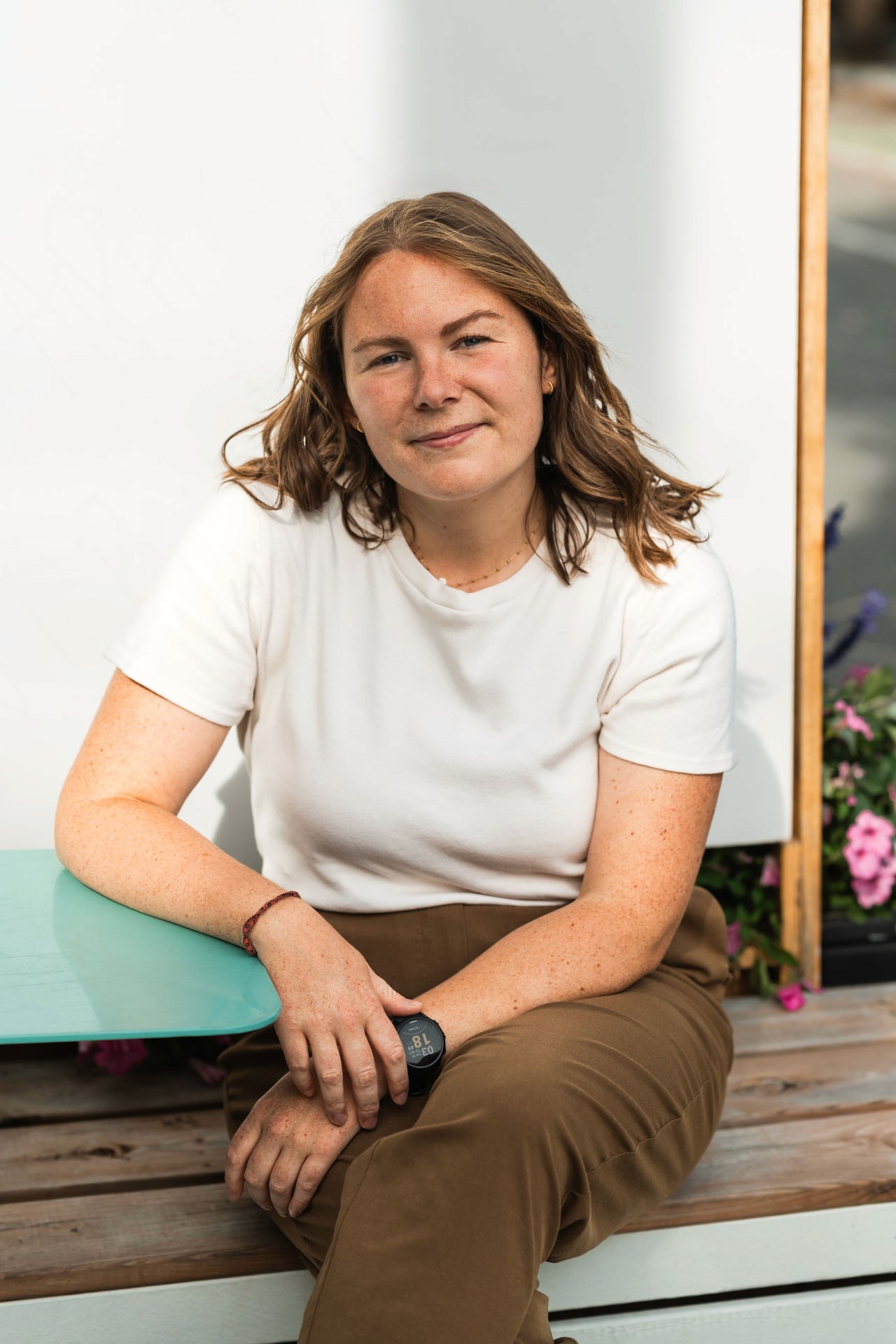 A thoughtful young person with dark hair gazes to the side, captured in soft black and white lighting.