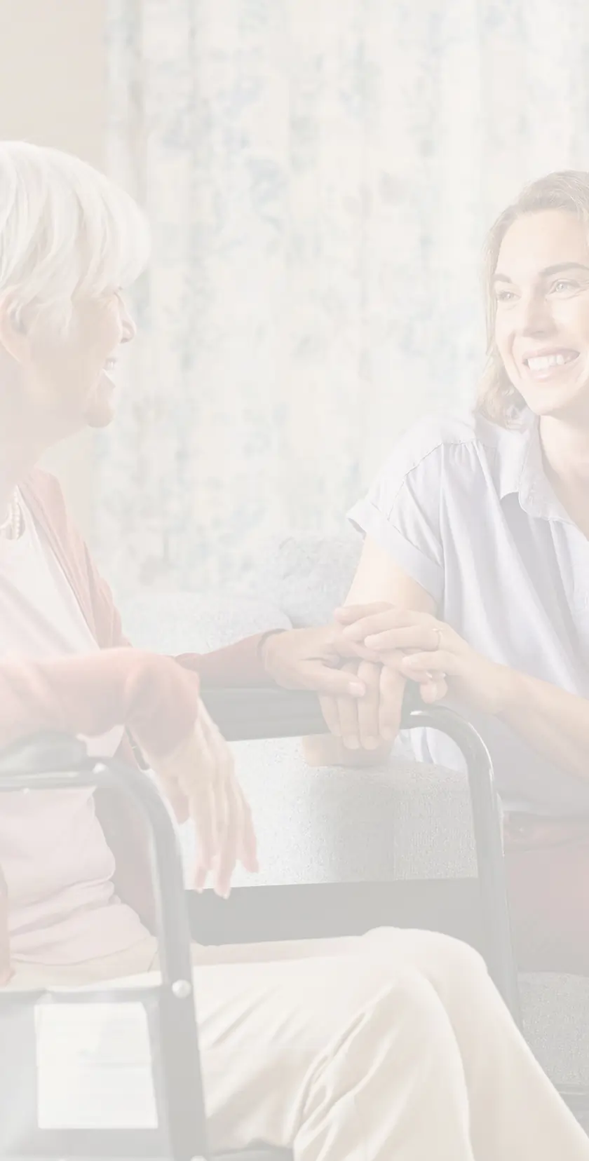Senior woman in a wheelchair sharing a laugh with her caregiver during an at-home visit in the Twin Cities