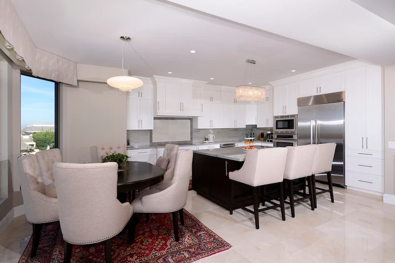 Elegant dining and kitchen area with modern finishes in Harbor Ridge Transitional Remodel.