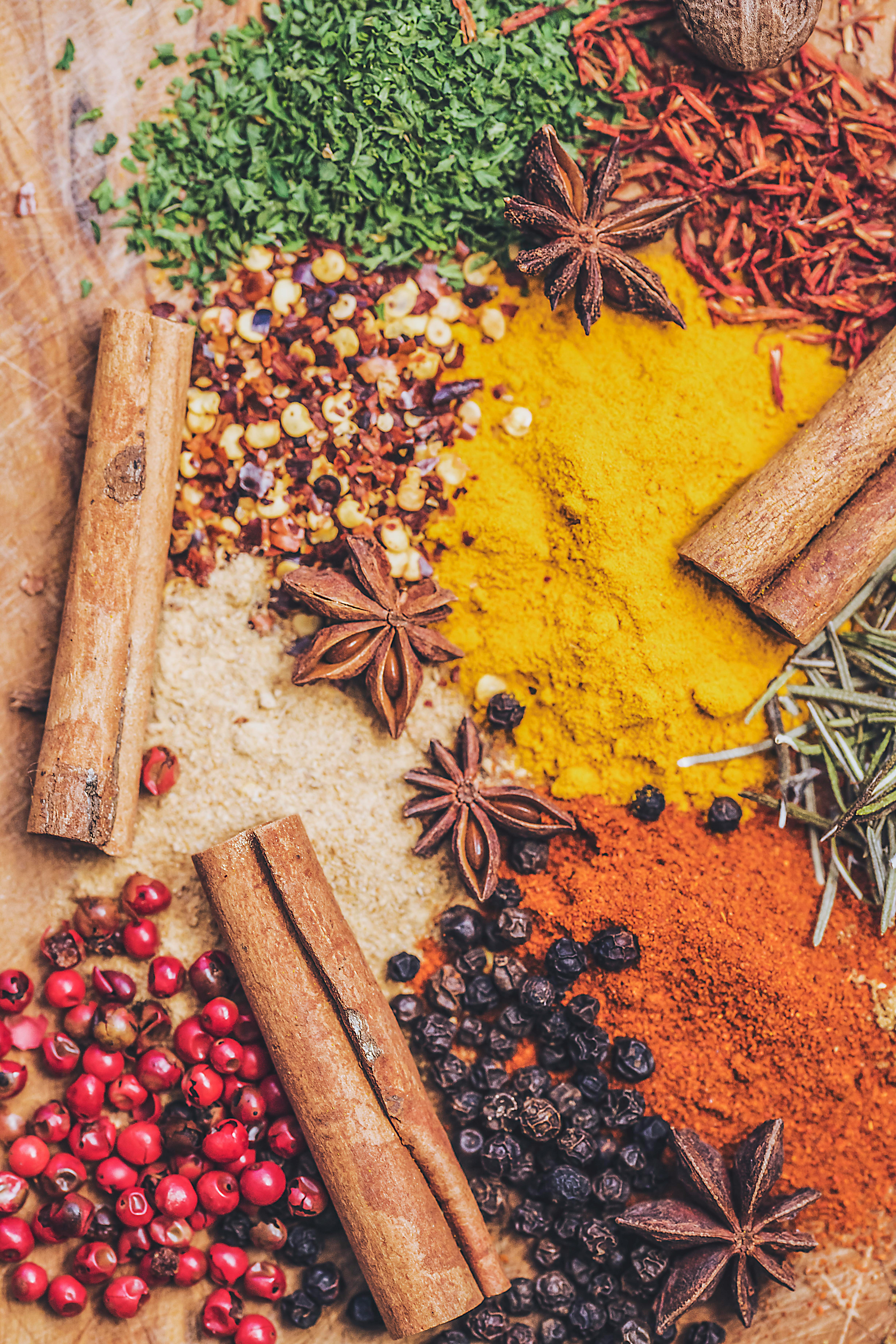 Assortment of whole spices including cinnamon sticks, star anise, and colorful ground spices, highlighting the diverse spice selection at International Food Market Orlando.