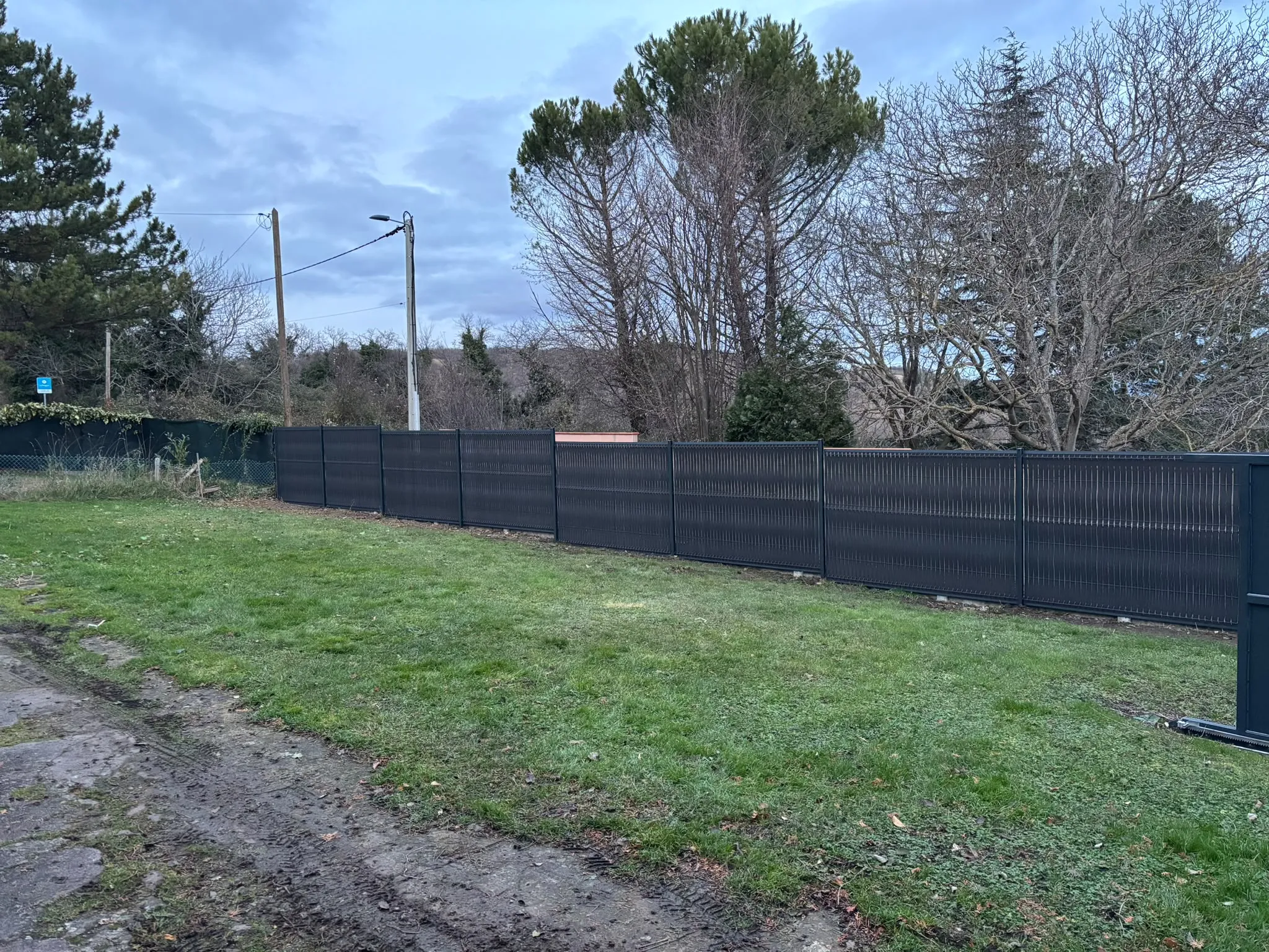 Clôture grise à lames horizontales autour d’un jardin — AFermetures