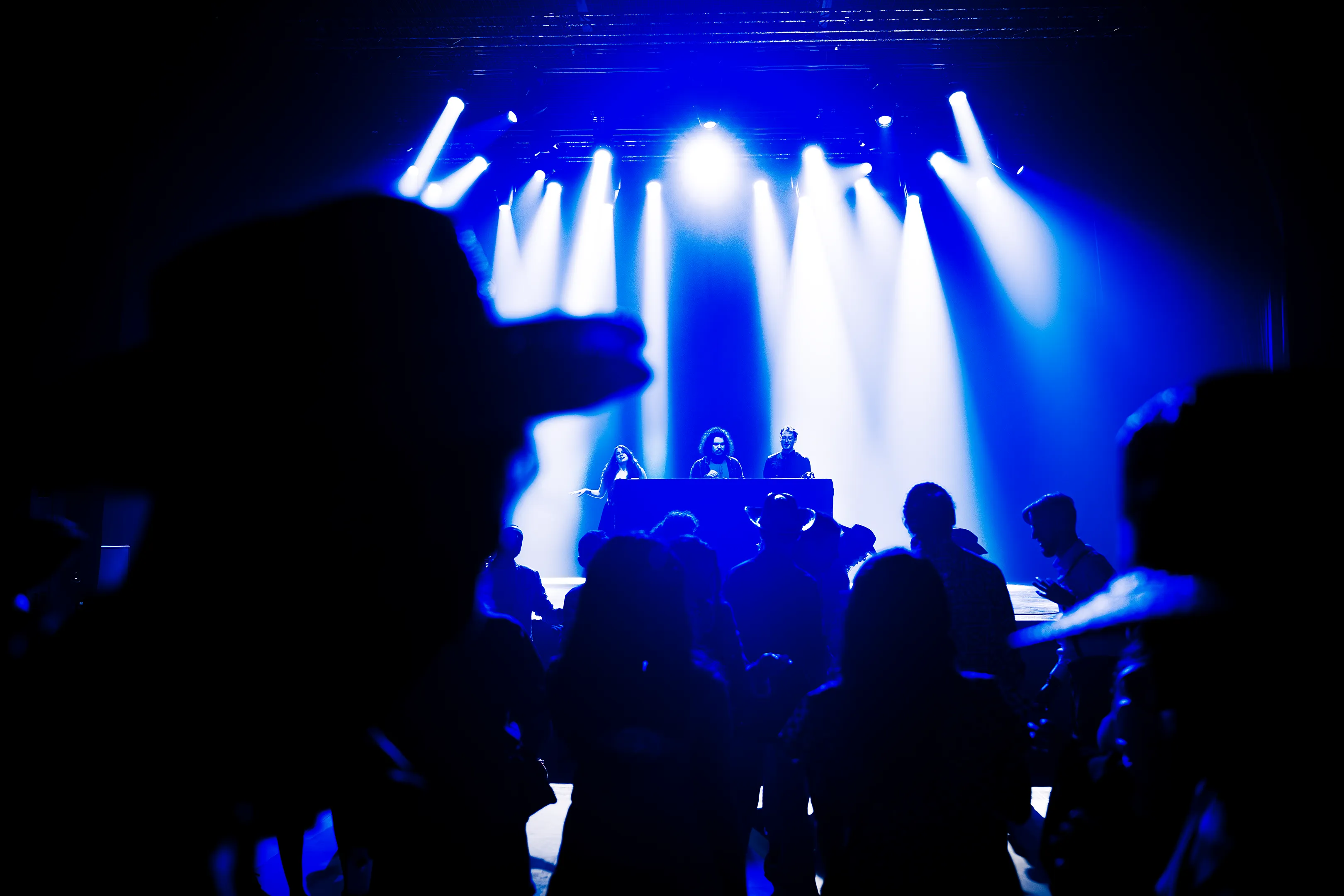 DJ set et public en silhouette sous lumières bleues lors du gala UGA à La Belle Électrique à Grenoble