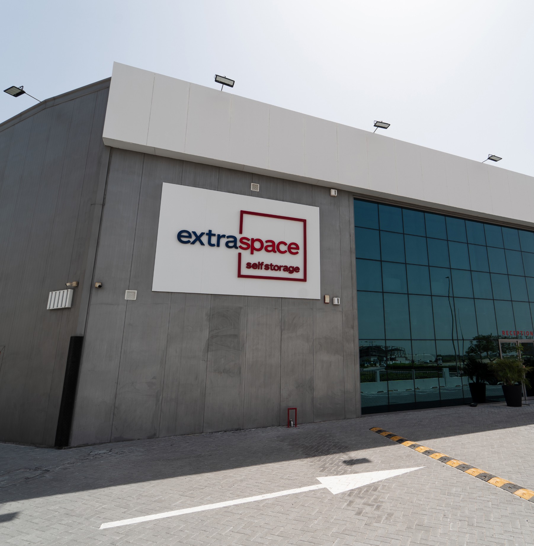 Exterior view of the Extra Space Self Storage facility, featuring clean architecture and secure gated access.