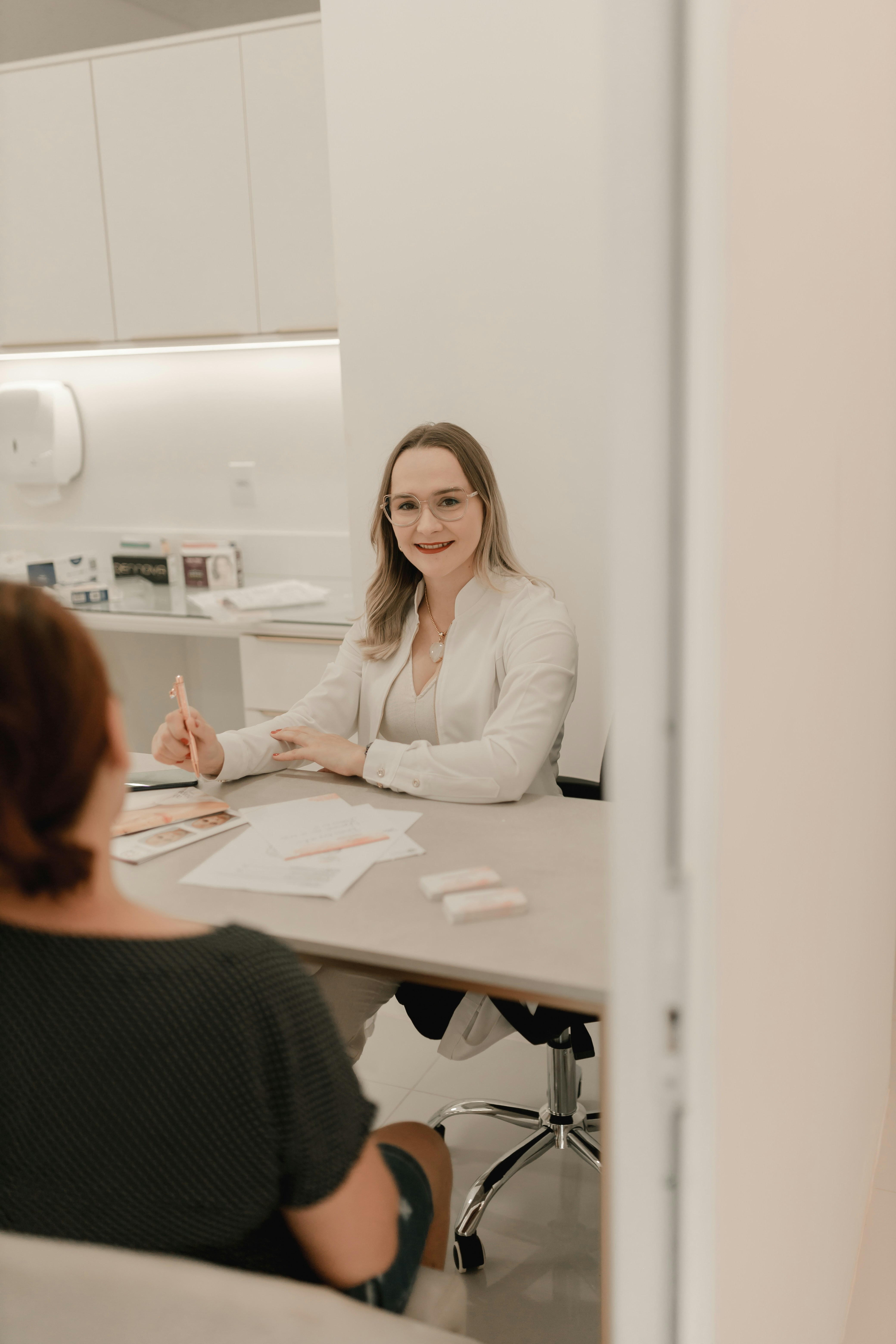 A woman sitting at a table in front of a mirror