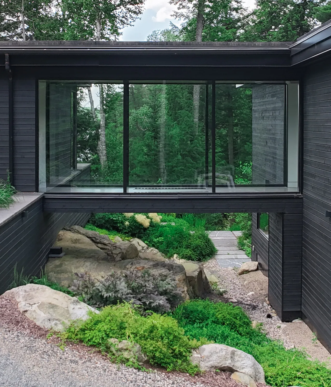 Custom garden design under an enclosed glass bridge.