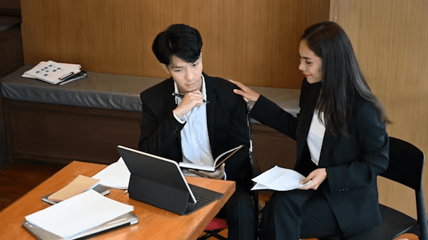 High school student conducting original ethics research with a PhD mentor in a university library setting
