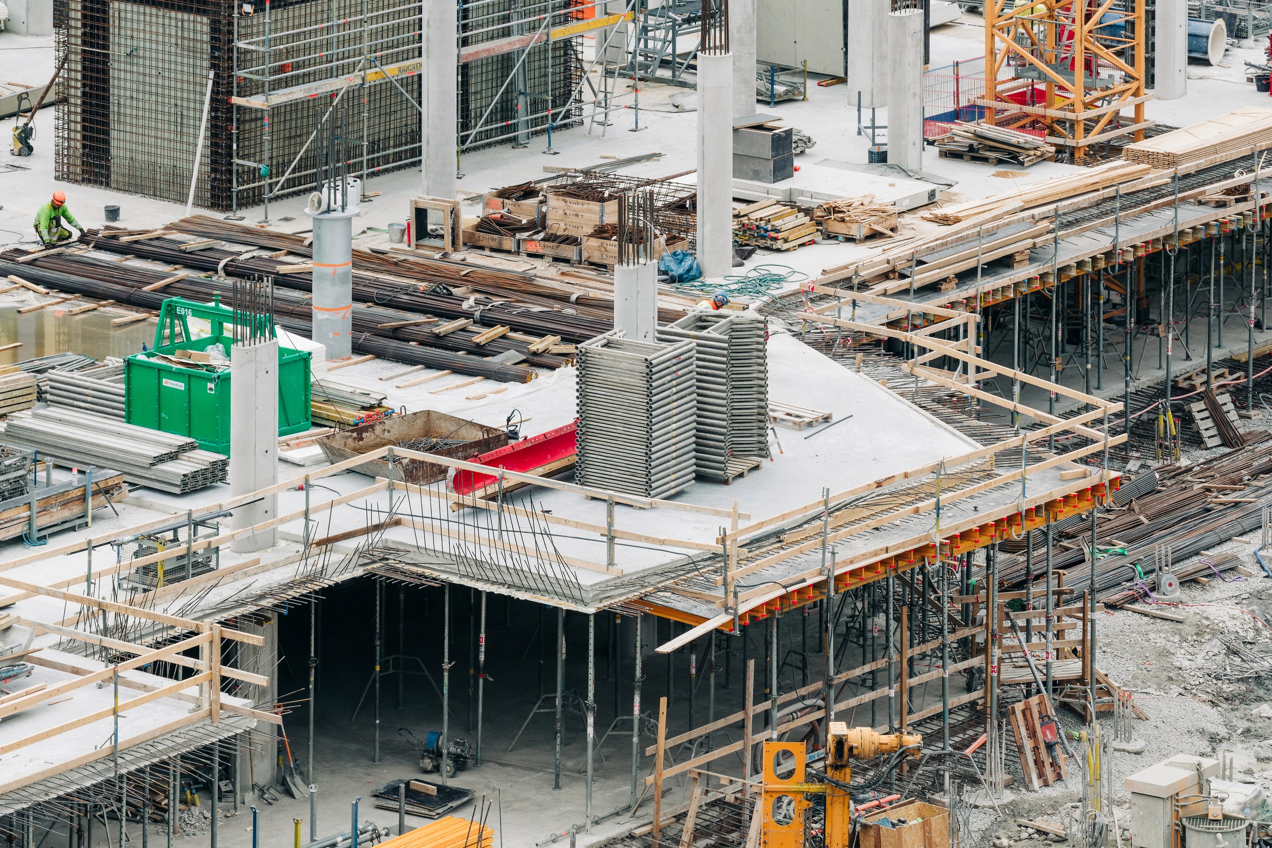 Talsinki construction progress, 31.05–01.06.2026: A close elevated view shows columns, stacked materials, scaffolding and an upper slab/formwork edge over an open lower level.