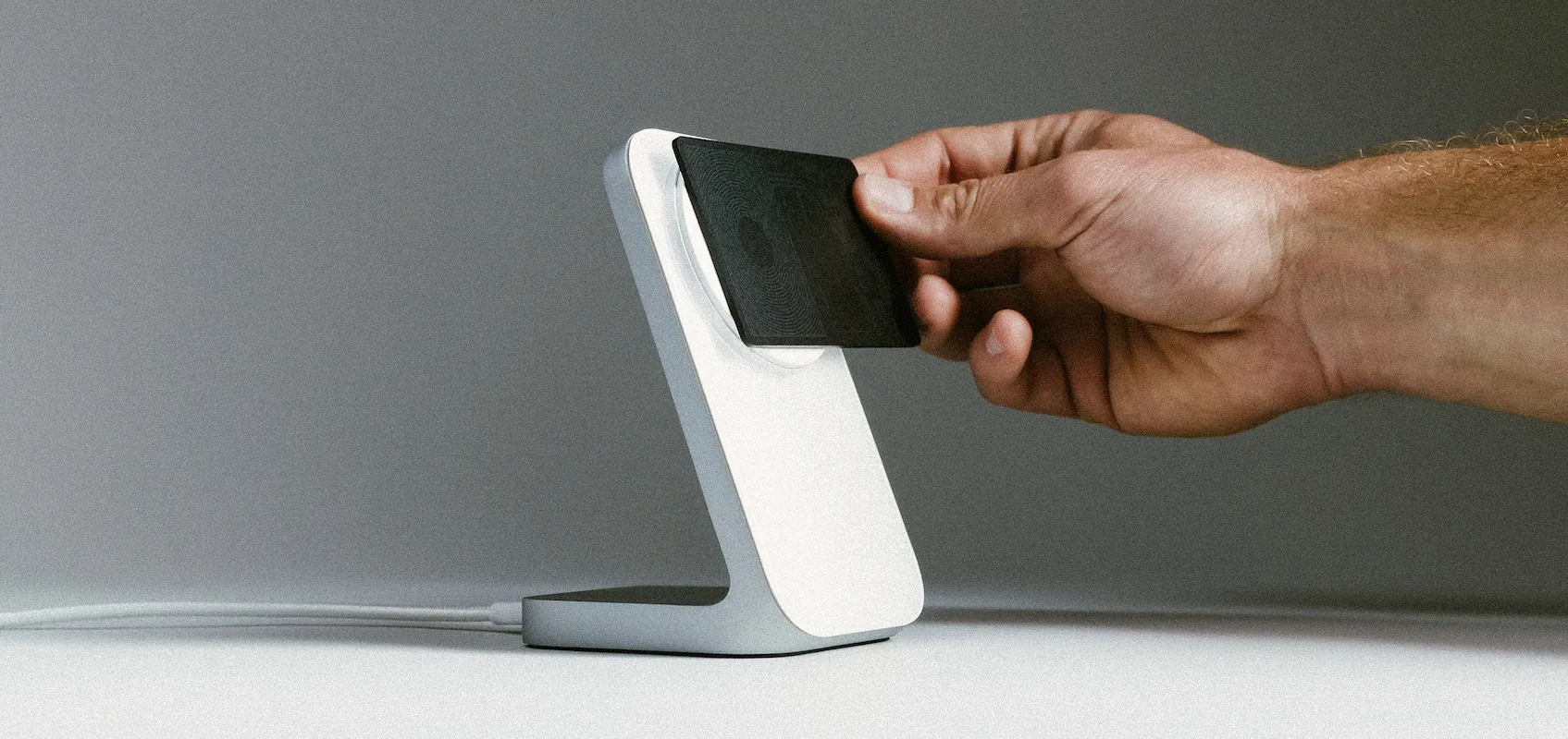 Person placing black card on wireless charging stand