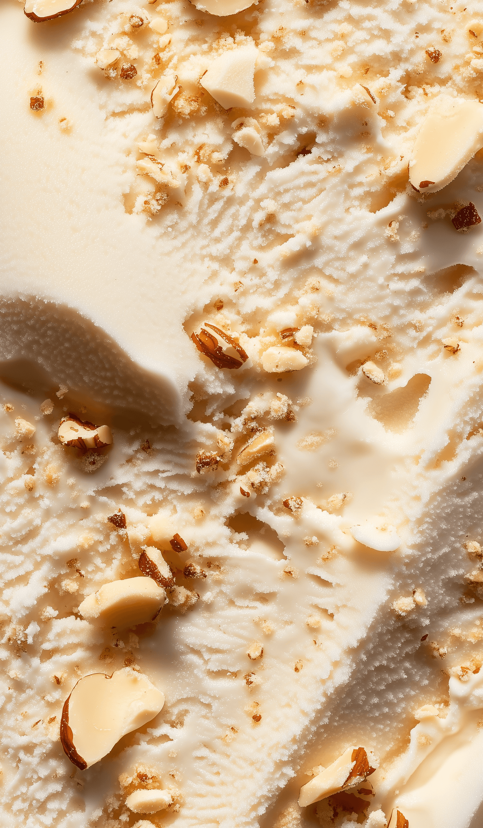 A close-up of the vanilla ice cream texture, with large milk-sized freeform shapes visible in it and some pieces of crushed almond nuts scattered on top. The background is white, creating an atmosphere that makes you want to eat the whole thing at once. This photo was taken using a Canon EOS R5 camera with high resolution. It has been captured in high definition, showcasing every detail.