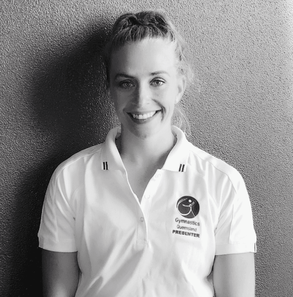A serene outdoor seating area with two chairs, surrounded by lush greenery and a glassed-in structure.