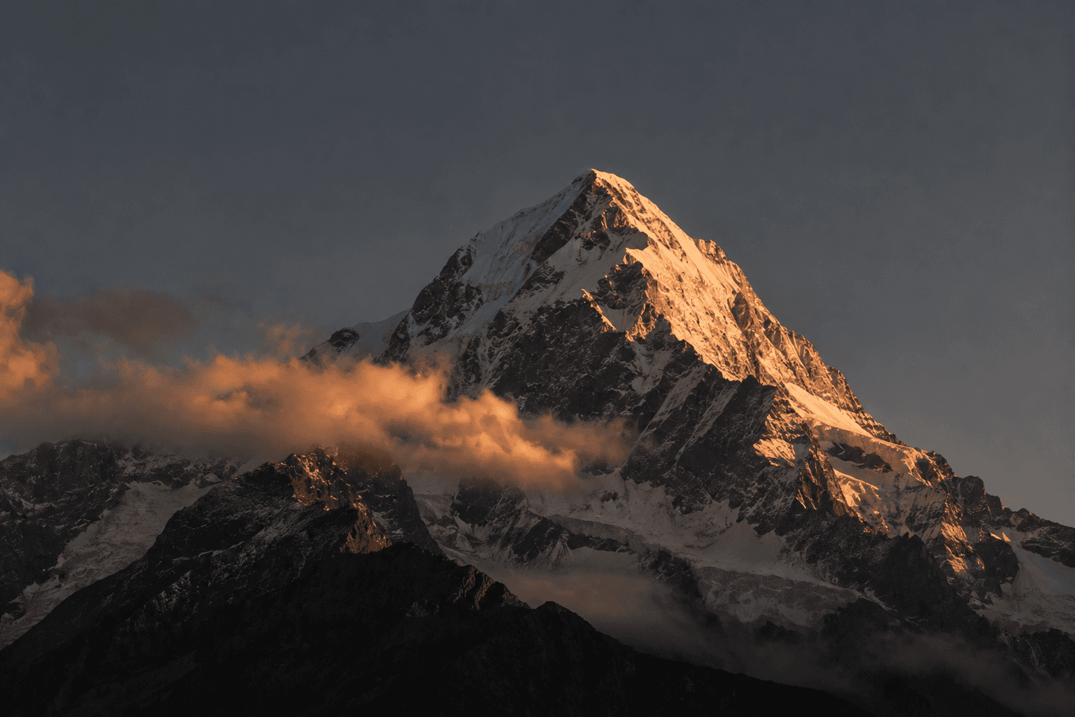 Snow-covered mountain peak above a rugged landscape