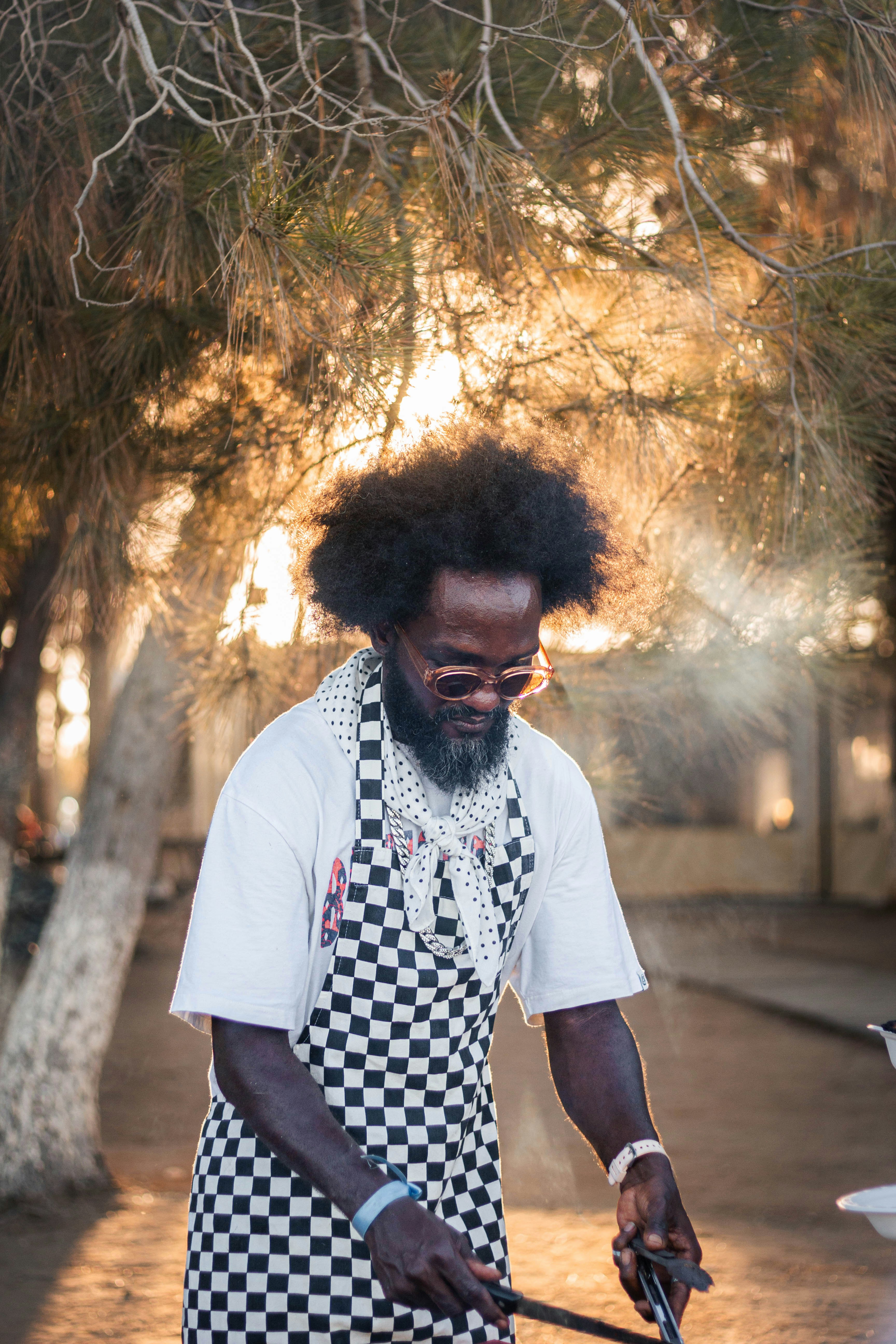 Calvin Osei in a checkered apron outside the shop