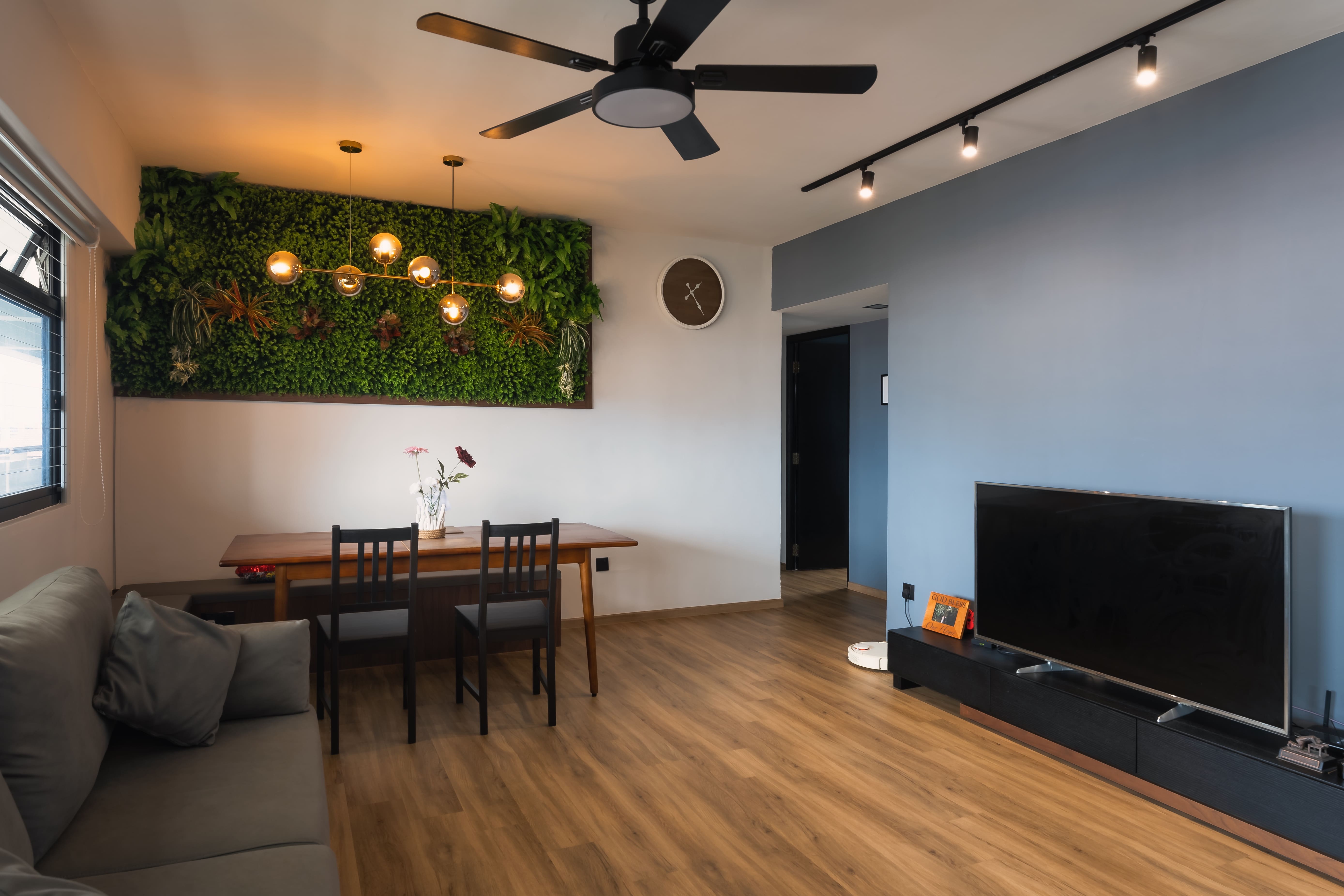 Dining and living area accented with a lush vertical garden wall, adding greenery and vibrancy to the warm wood tones.