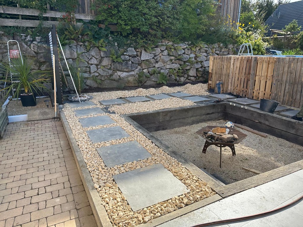 a man in blue overalls working on cement