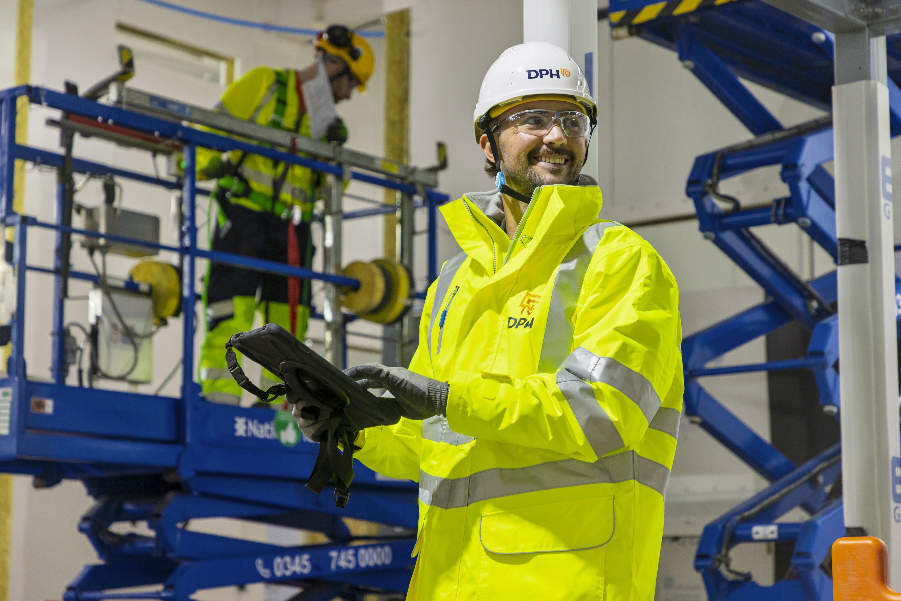 Modern glass building with illuminated facade and cityscape view at sunset