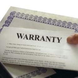A close-up of a warranty document with the word "WARRANTY" prominently displayed, partially held by a hand.