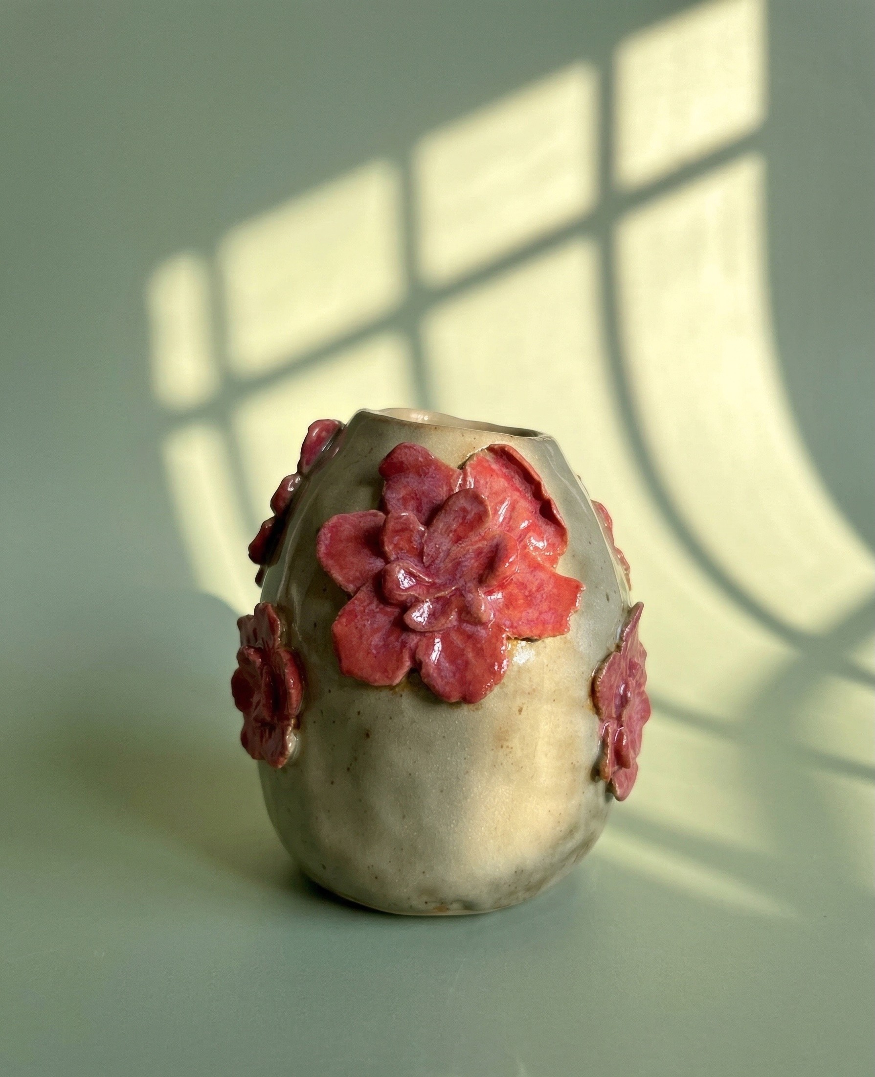 an hadmade ceramic vase decorated with flowers