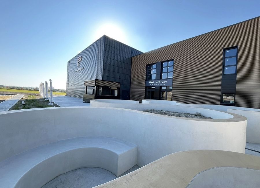 Façade de bâtiment industriel avec bardage métallique ondulé et mur en briques.