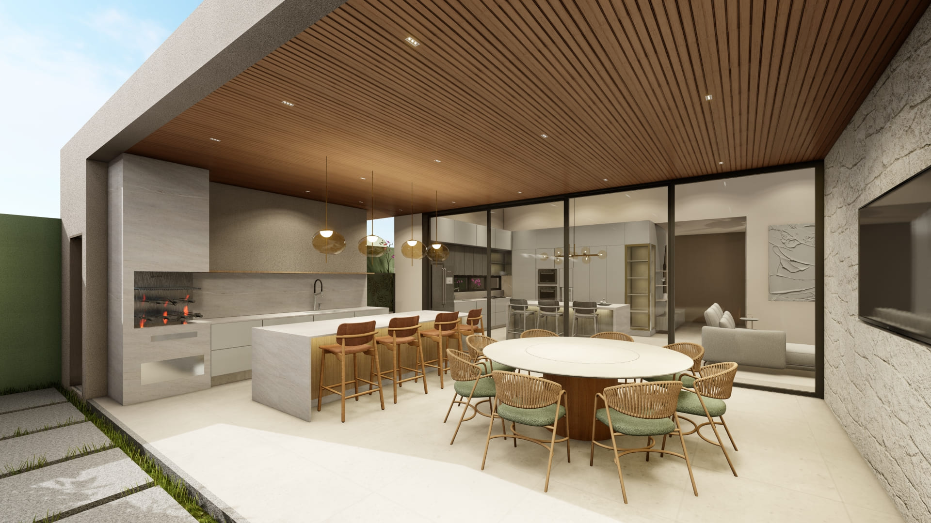 Nesse projeto, o destaque são os cobogós que percorrem a casa, inclusive o corredor. A sombra que eles projetam no piso muda conforme o sol e deixa o ambiente mais aconchegante.  Como complemento, a casa traz materiais naturais como a pedra e a madeira, que equilibram a composição e reforçam a conexão com a natureza.  Para a área gourmet, projetamos uma ilha de mármore, mesa redonda e aberta direto pro jardim, sendo uma área de lazer que se íntegra com a natureza. Inclusive, um detalhe é que a cozinha e o lado de fora dividem o mesmo teto de madeira.