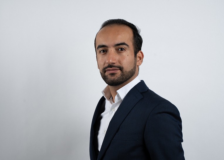 Foto van Niwar, eigenaar van vsocheque.nl. Man in pak die de camera in kijkt.