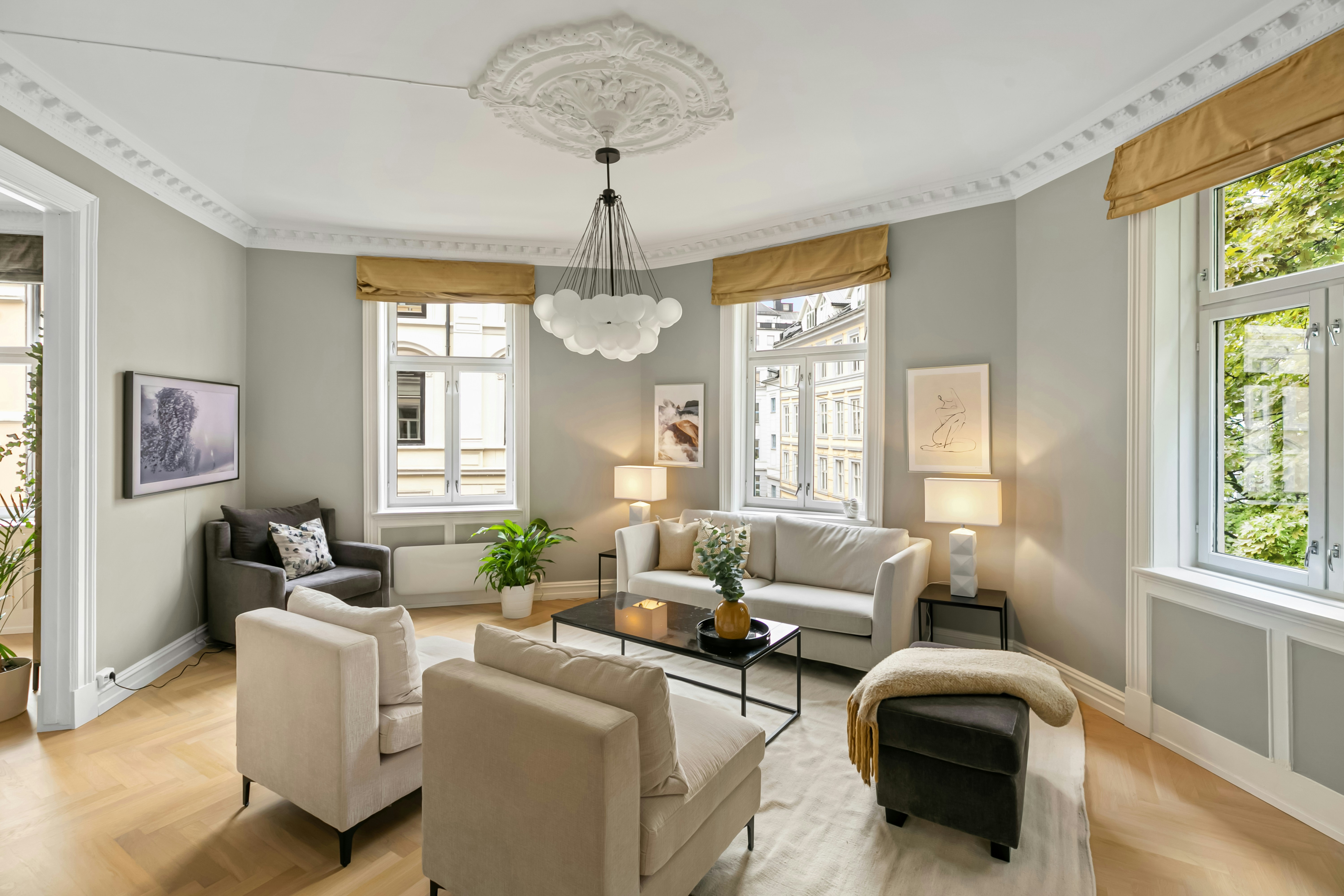Refined European apartment salon with plaster ceiling rose, bubble chandelier, and herringbone parquet