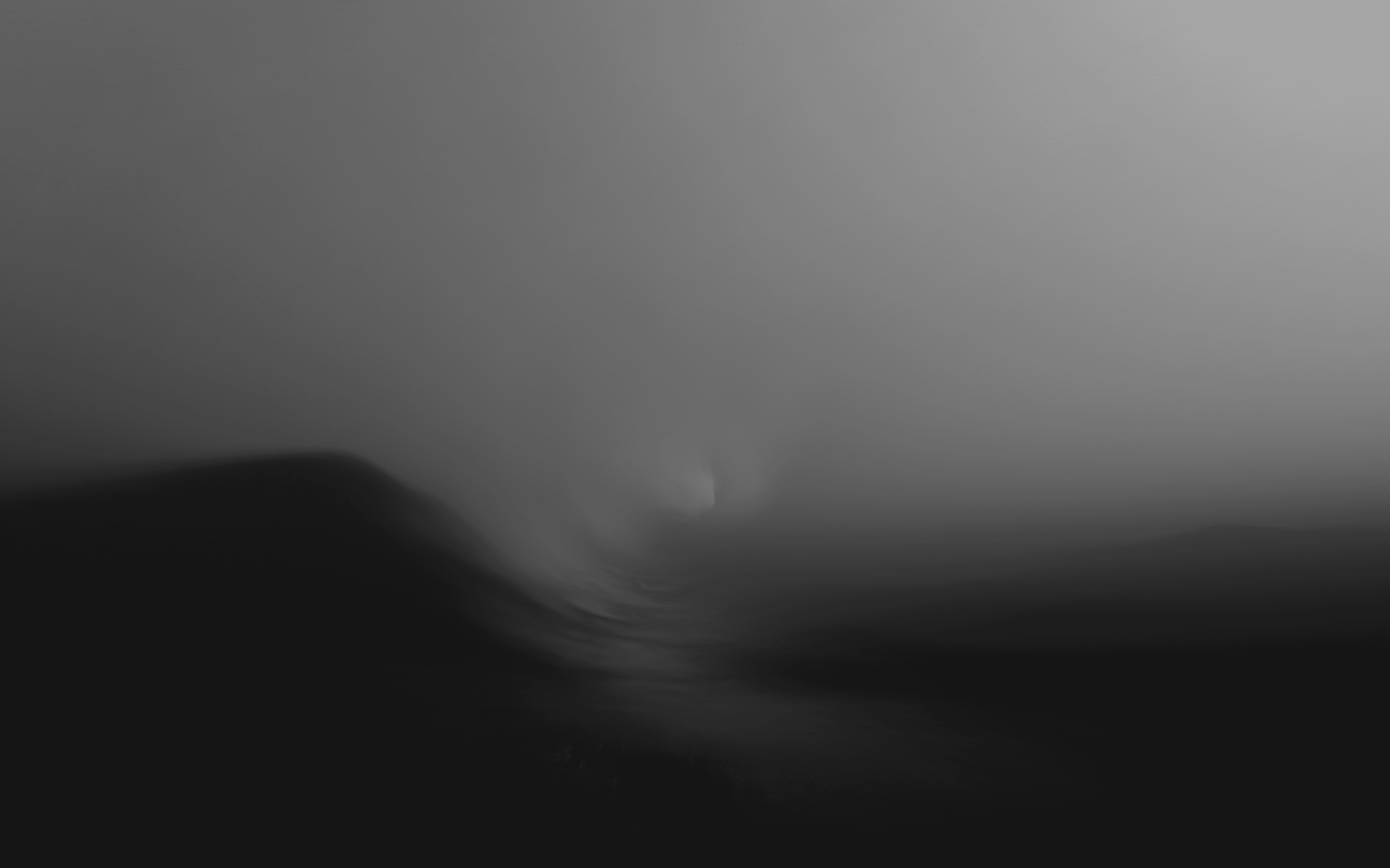 A dark, moody black-and-white abstract landscape of misty, rolling waves in an atmospheric gradient.