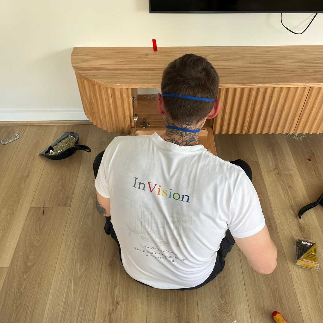 A young person with long, wavy hair sits in front of a plain background, looking directly at the camera.