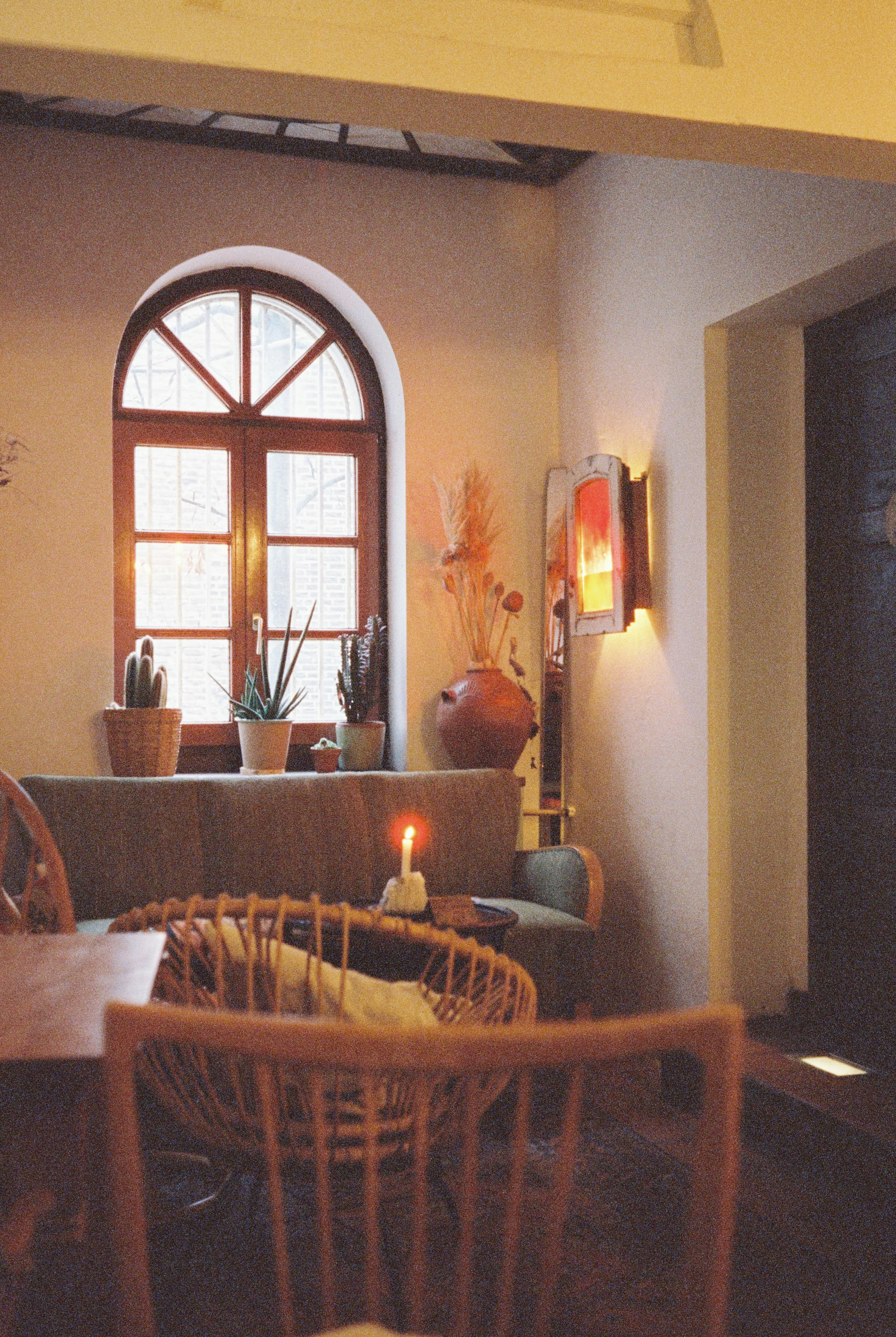 Cozy room with arched window and candle light.