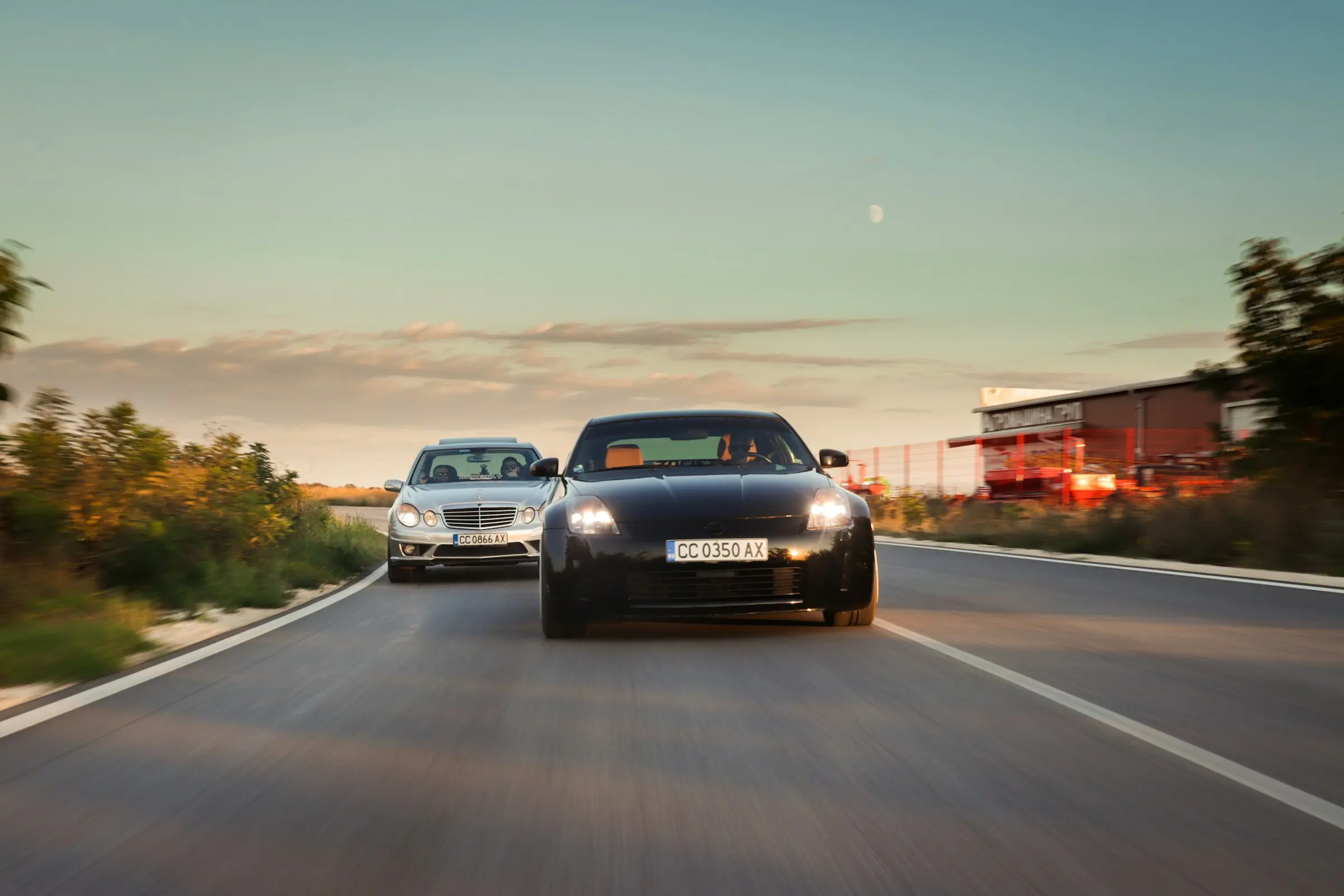 Two cars driving on a highway at sunset, representing car dealership inventory and buyer trust.
