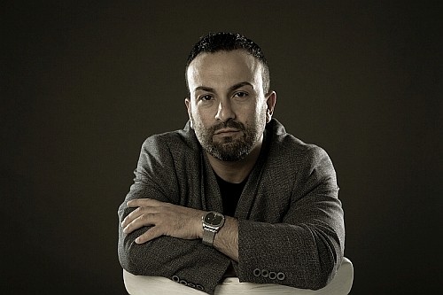 woman in brown long-sleeved top standing beside wall