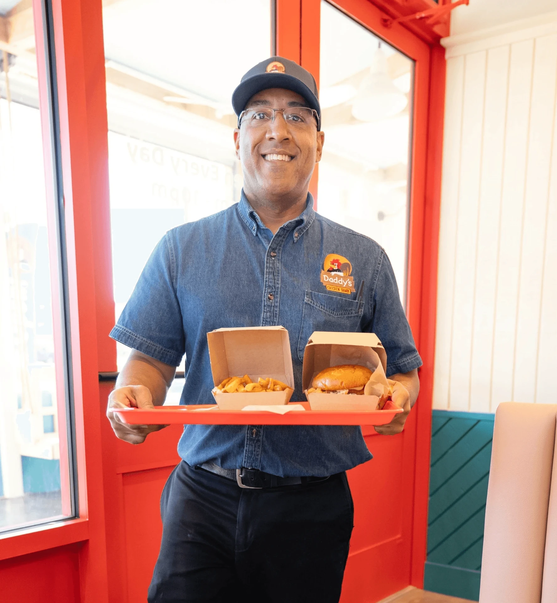 Daddy’s Chicken Shack team member holding a tray of sandwiches