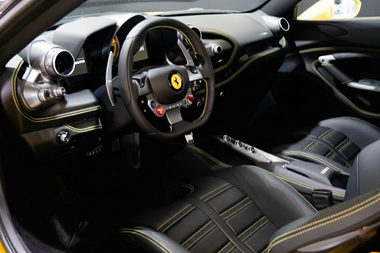 Ferrari F8 Tributo interior with carbon fiber steering wheel, digital cockpit, and premium leather cabin designed for a high-performance drive.