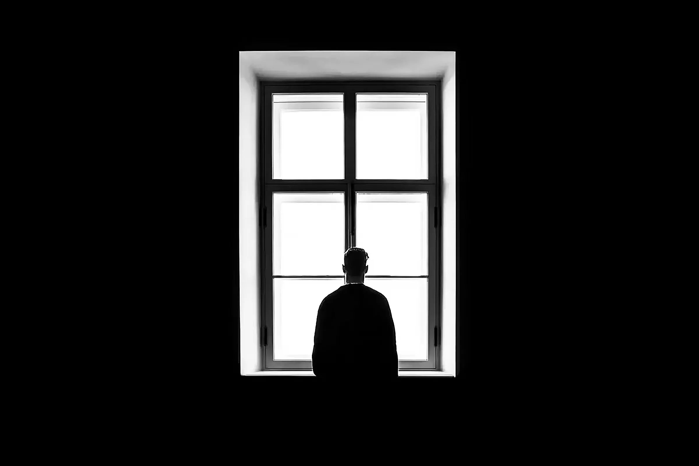 A man stands by the window.