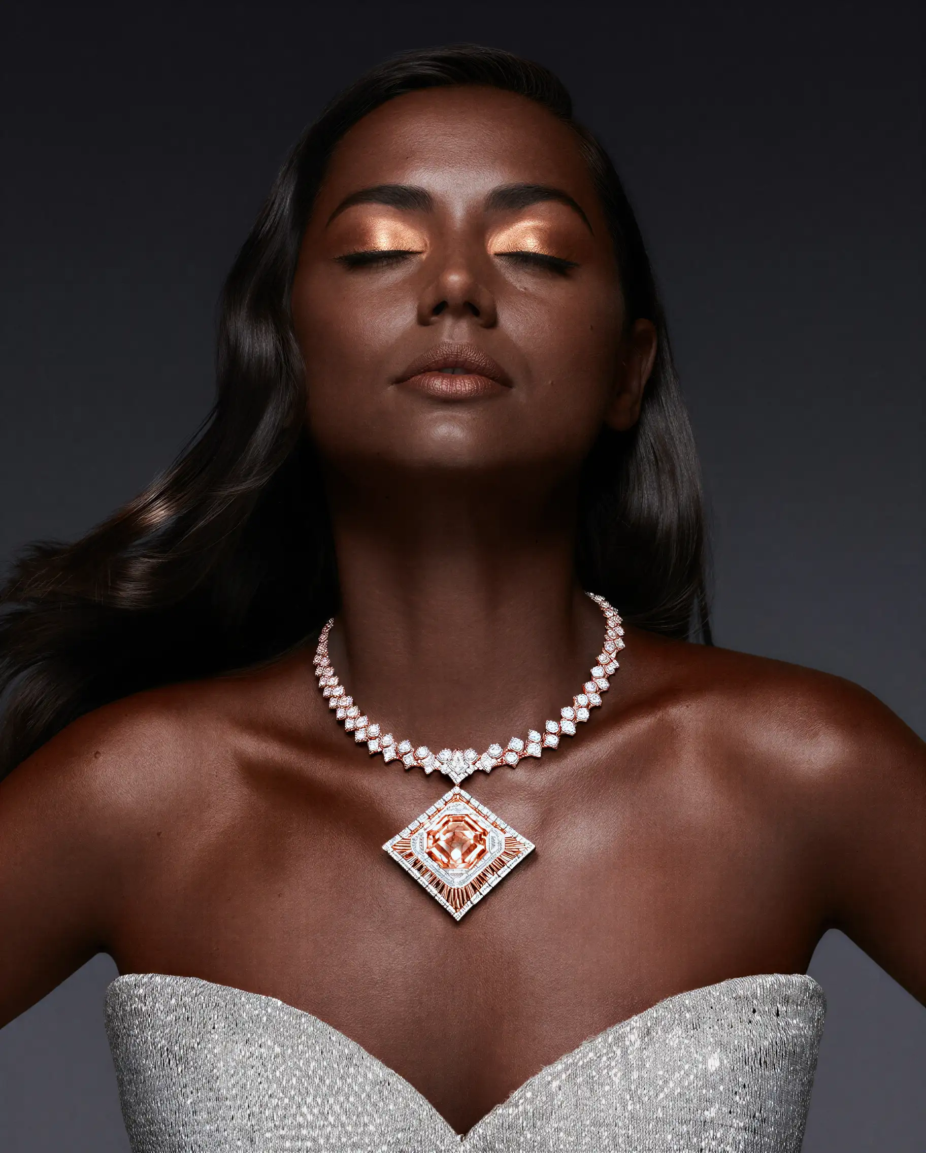 Three young people walk through a dry grassy field.