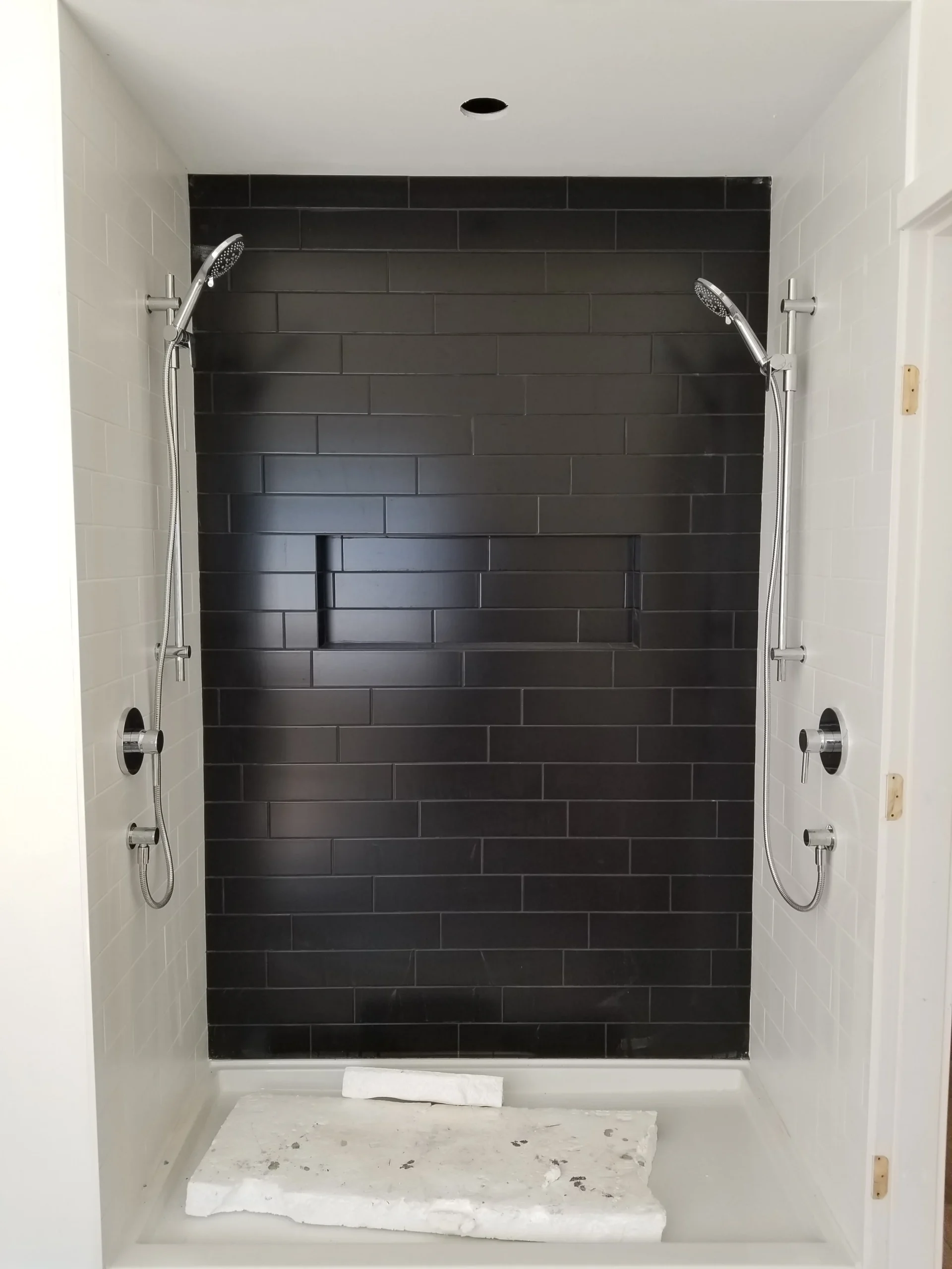 Modern two-story home with large glass windows, warmly lit interiors, and a balcony. Surrounded by trees and a manicured lawn at dusk. Cozy ambiance.