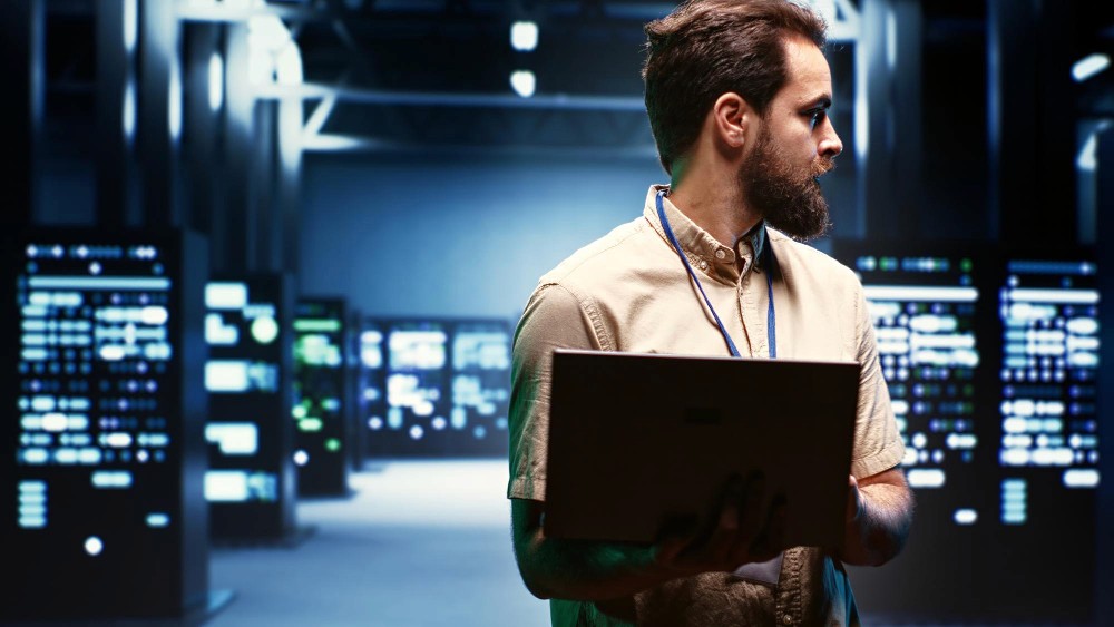 Man with laptop in a servers room