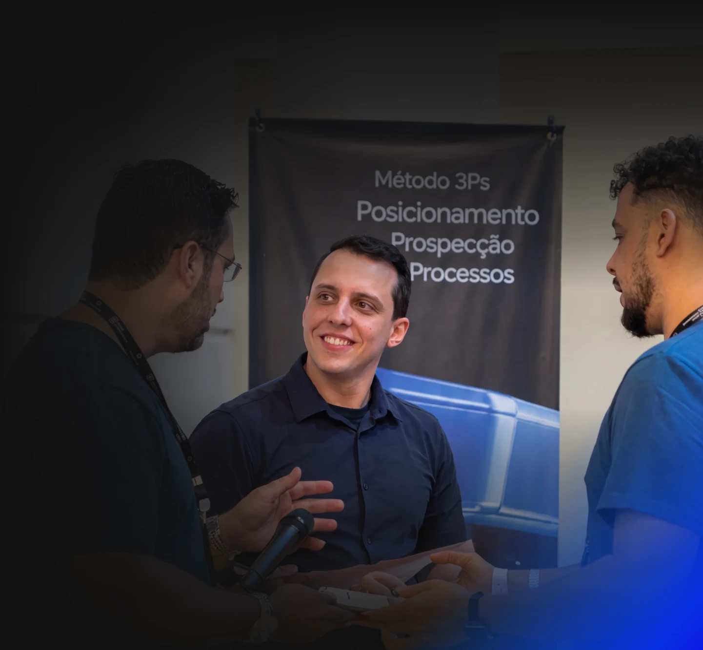 Mentor conversa com donos de agência em frente ao banner do Método 3Ps