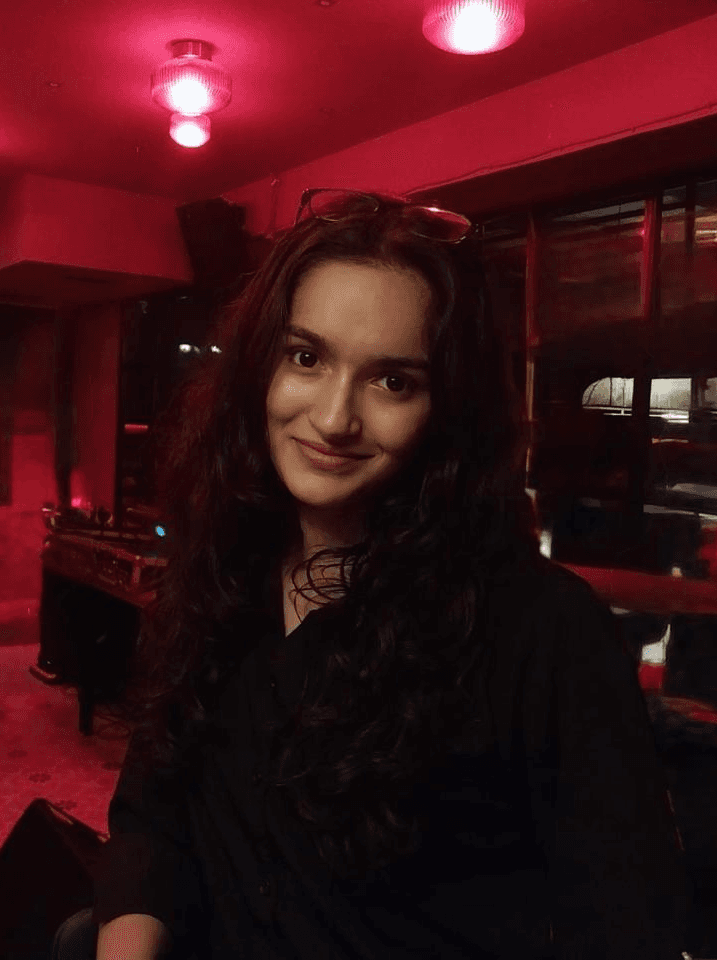 Monochrome product shot: black-capped cosmetic bottle with dynamic water splash on a clean white background.