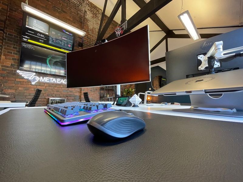 Two men discuss a project while standing at a laptop in an office.