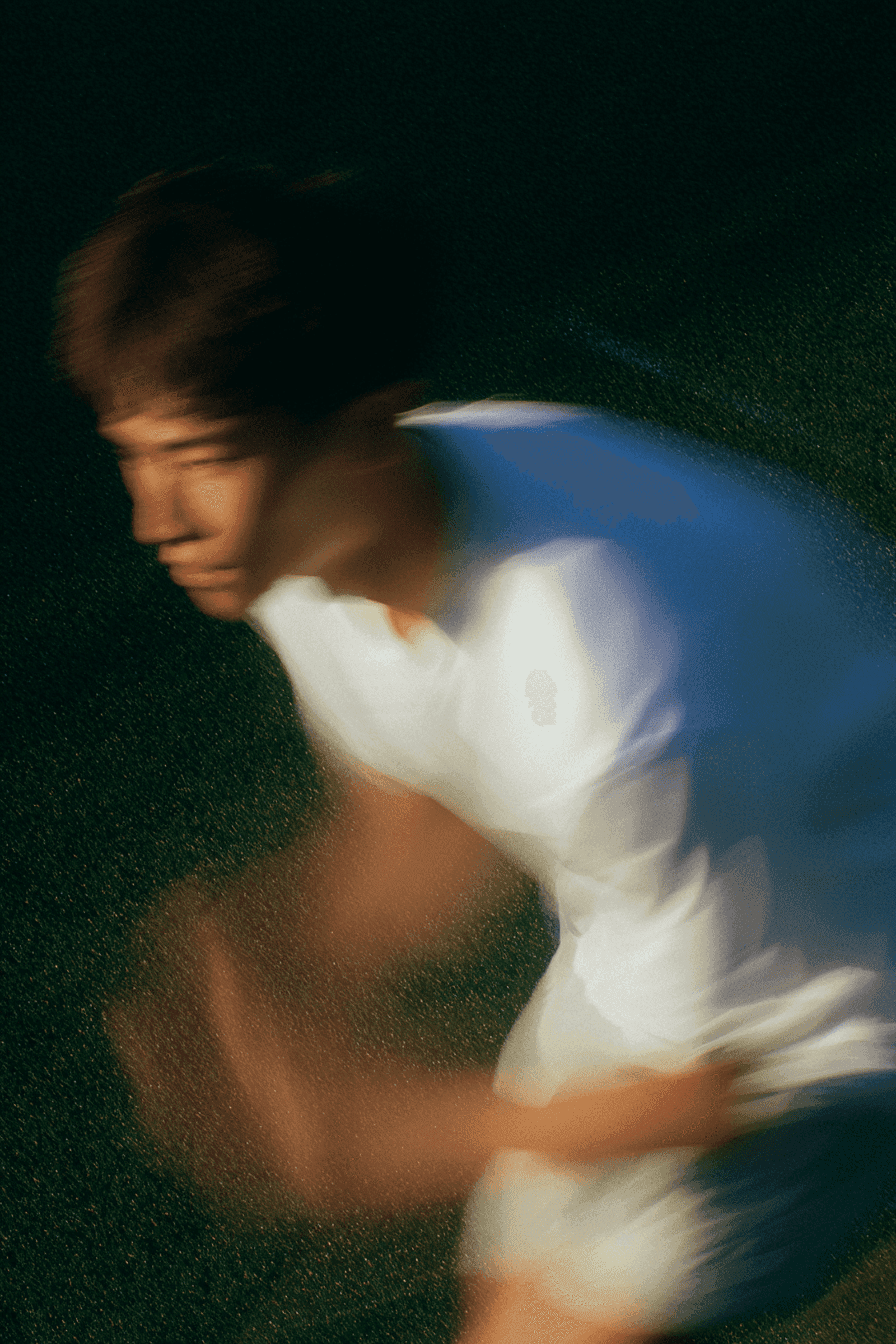 Dynamic motion blur of a performer in white, conveying speed and energy.