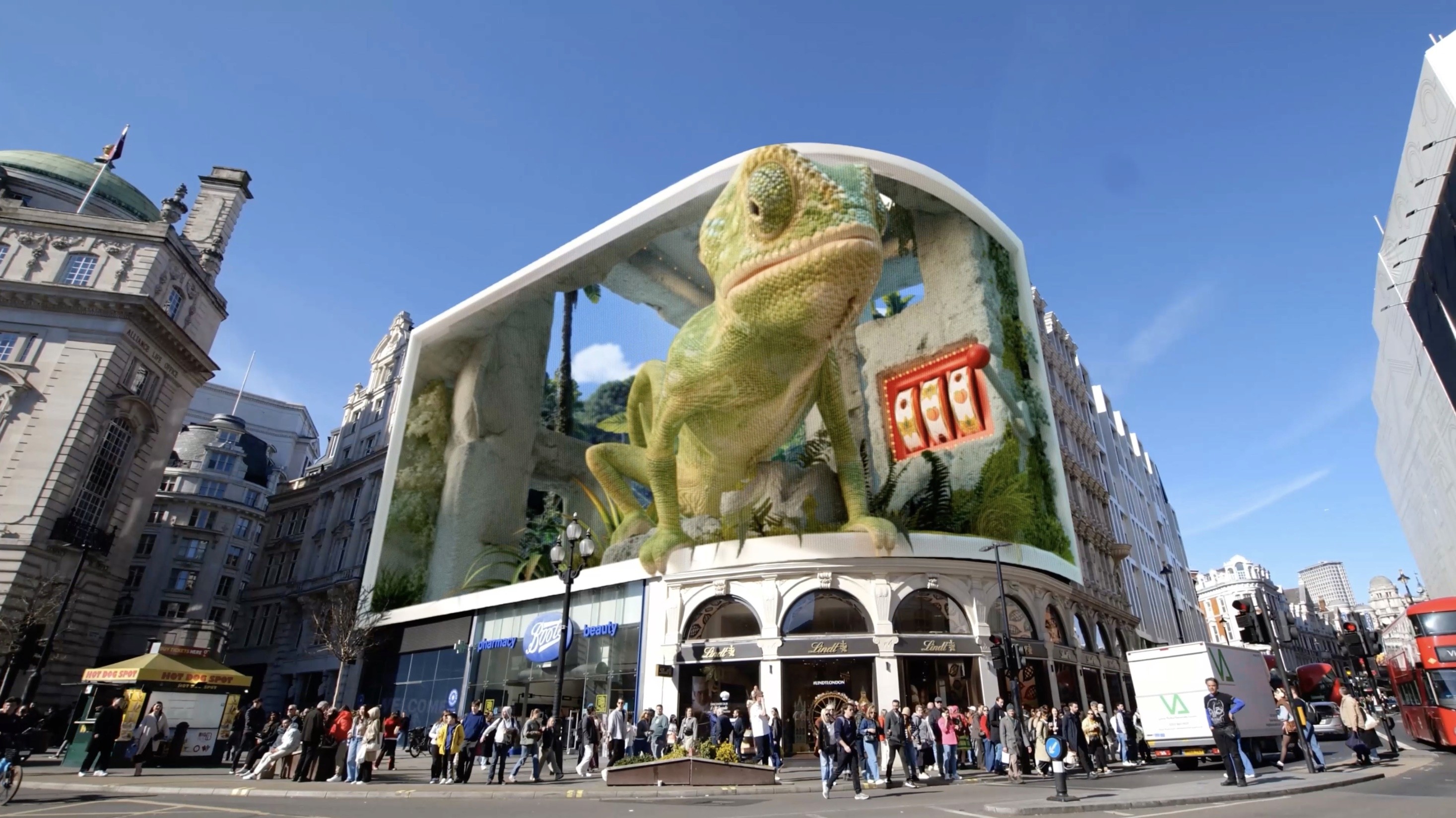 CGI of a massive green chameleon and a digital slot machine on a city rooftop.