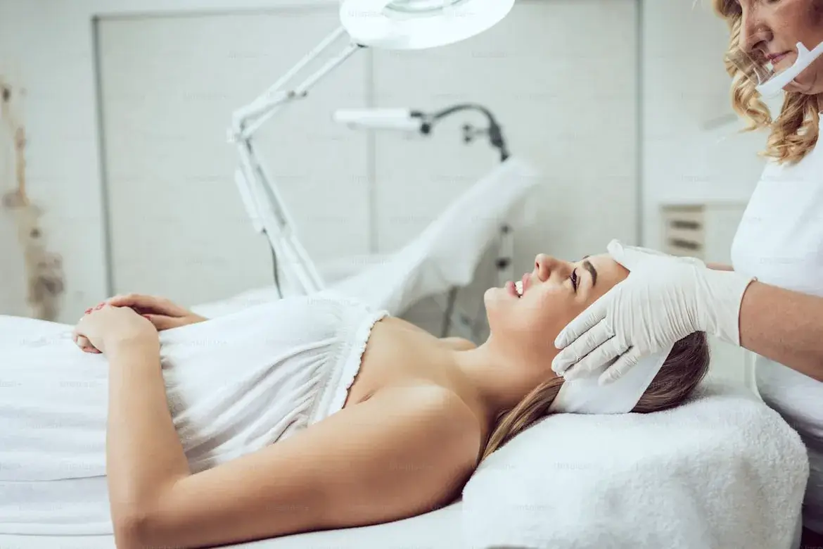 Woman receiving professional aesthetic care in a medical spa setting, representing advanced facial and skincare treatments focused on natural, lasting results.