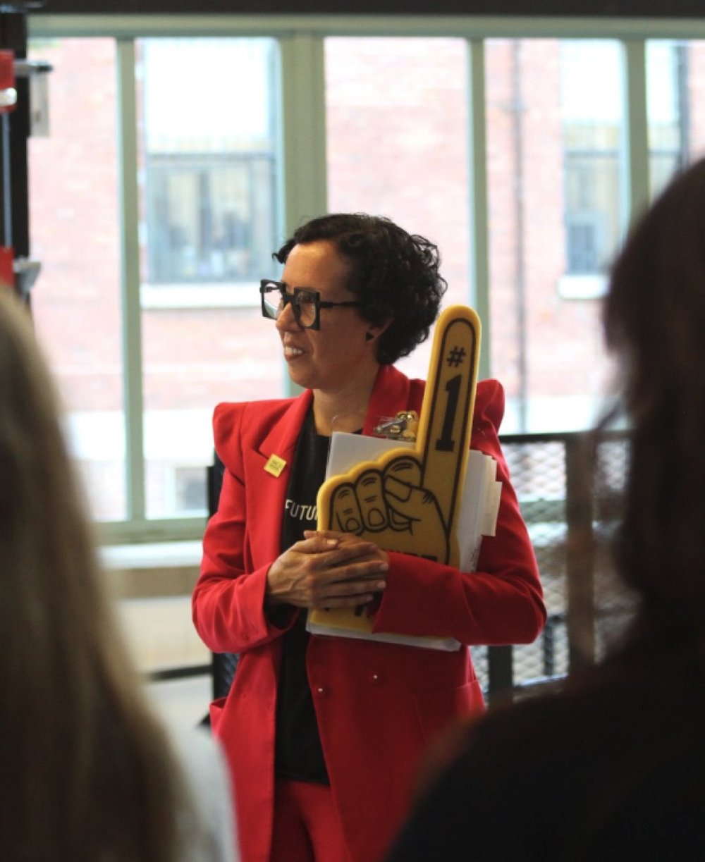 Amanda Ramos (WIN CEO) holding a giant foam finger