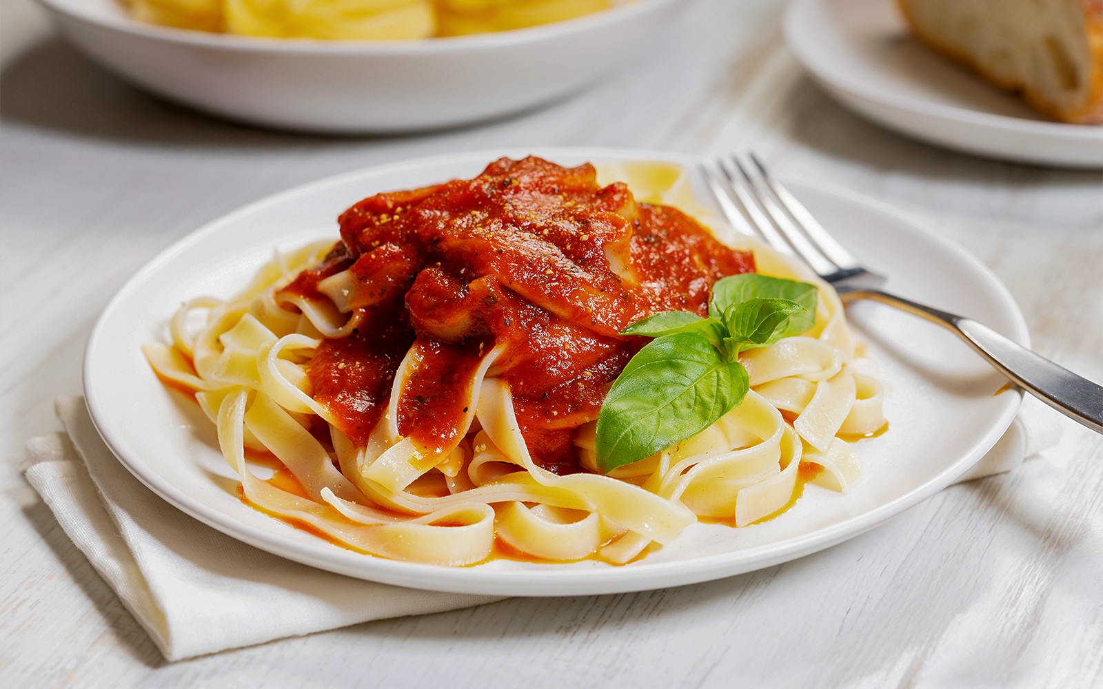 意大利餐廳的白色盤子上擺著番茄醬意大利寬麵。