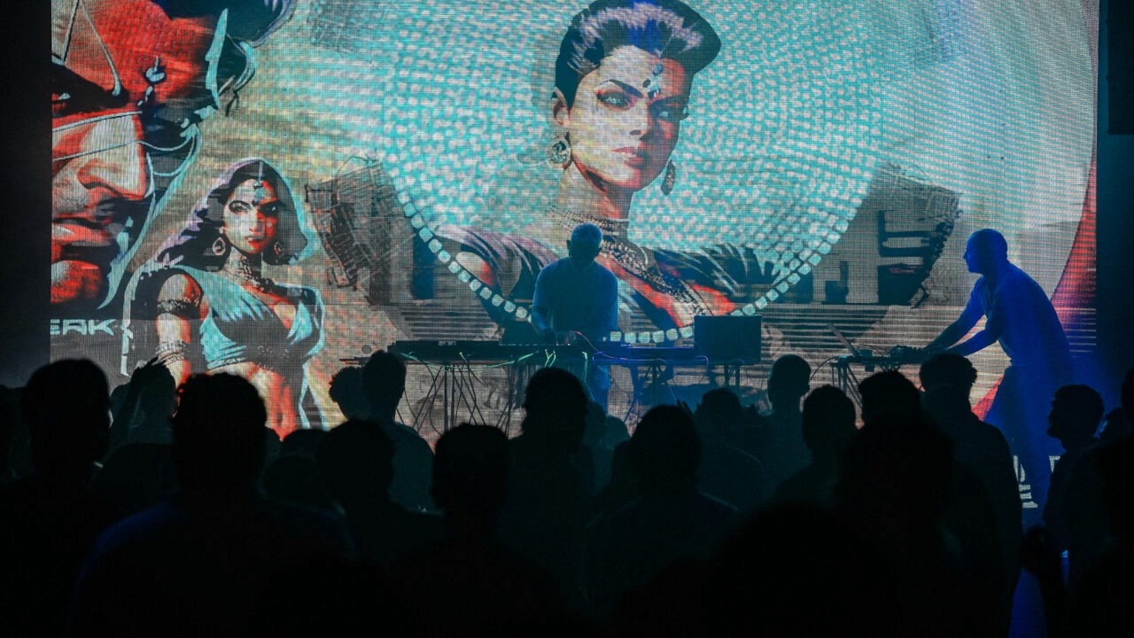 A single red mushroom with white spots on forest floor.